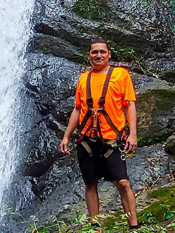 Picture of Erick Gutierrez standing in from of a waterfall by Costa Rica Unexplored. 