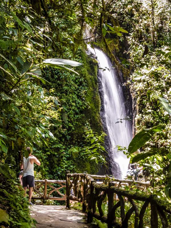 A man standing while he admired a Waterfall at Alajuela.