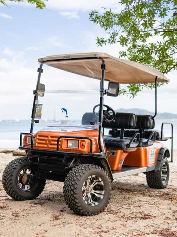 A golf Cart in from of Tamarindo Beach