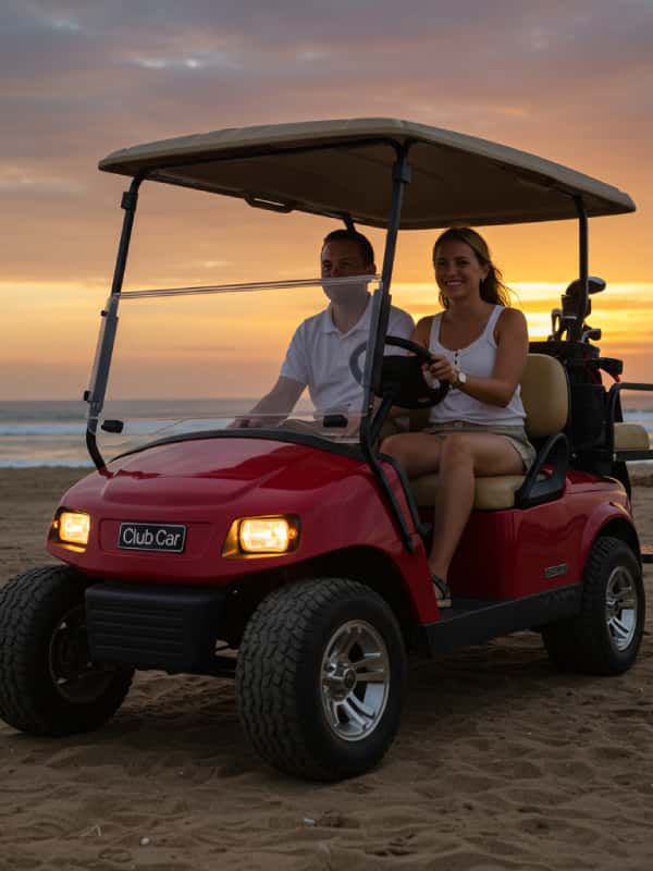 a man and woman driving a golf cart on a beach