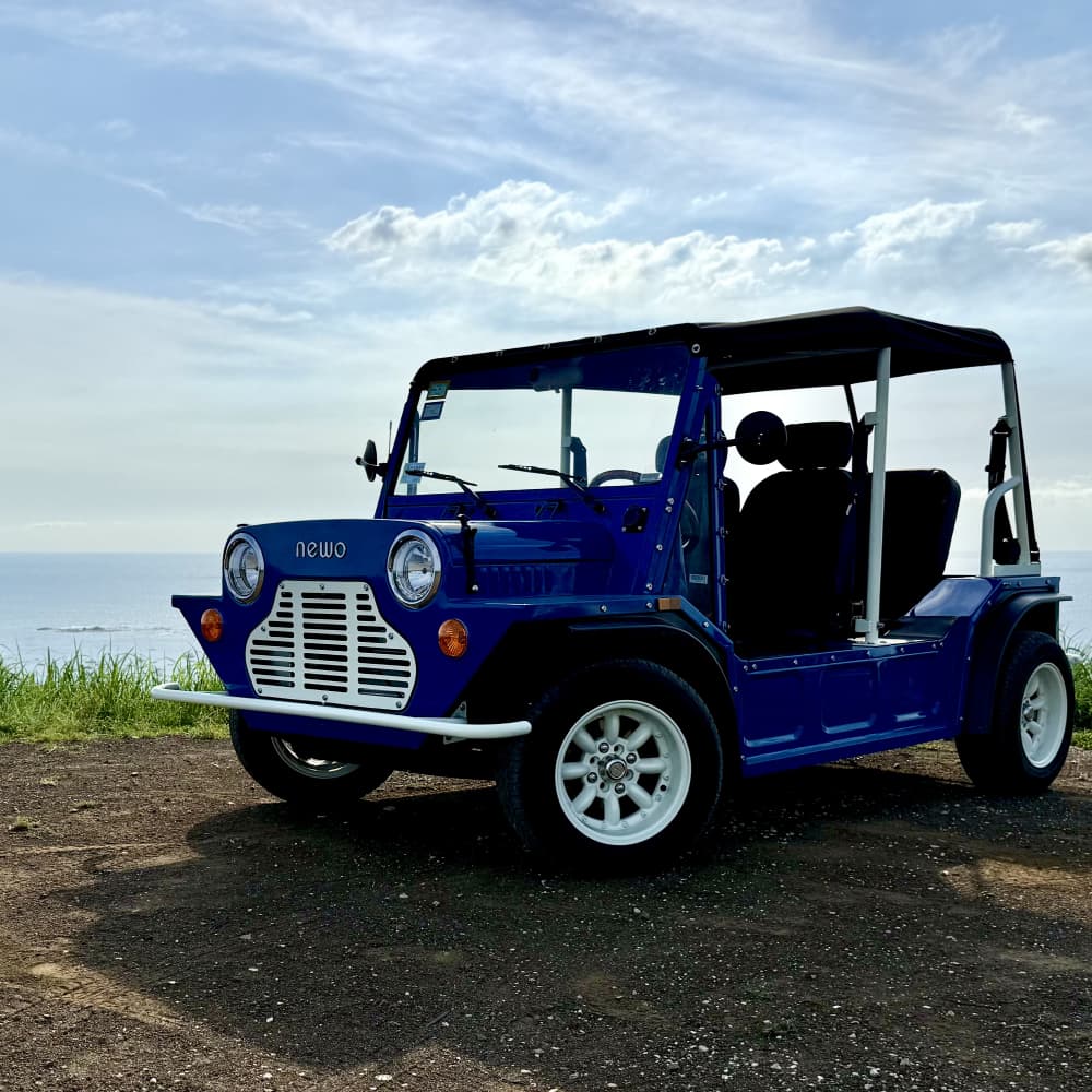 a blue car parked on a dirt road